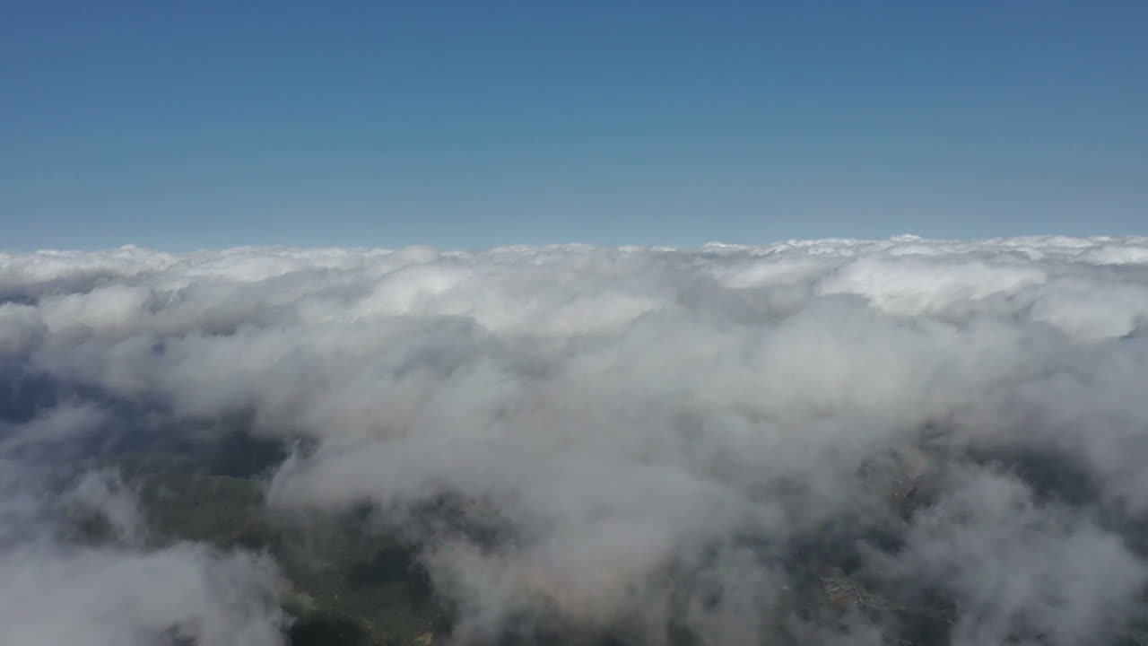 Flying above a sea of clouds toward snow-capped mountains